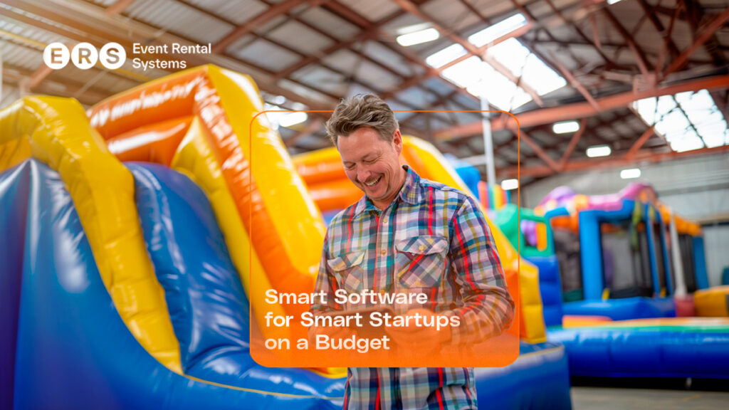 Rental business owner viewing phone in warehouse with inflatables