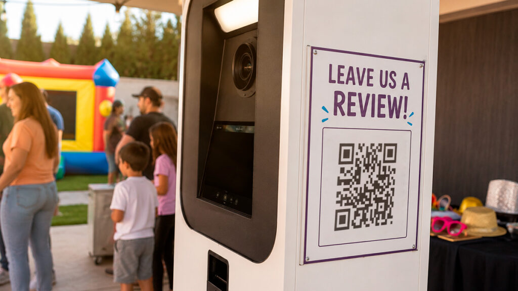 A rental photo booth at a backyard party displaying a QR code requesting a review